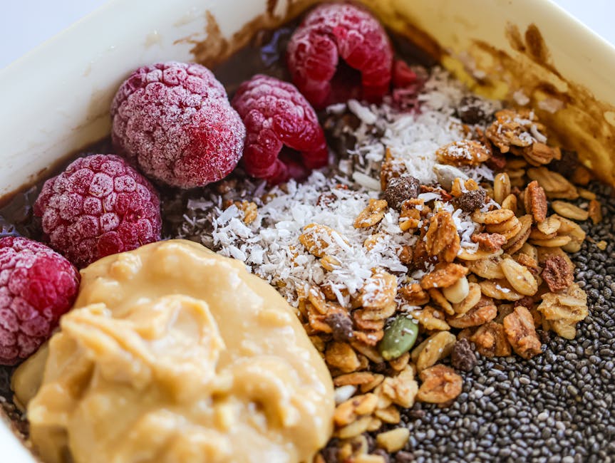 Delicious breakfast bowl with fresh raspberries, granola, and nut butter for a healthy start.