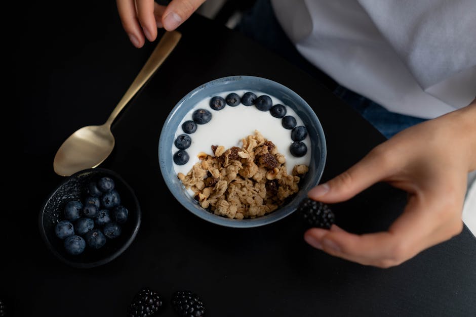 A delicious breakfast bowl featuring granola, yogurt, blueberries, and blackberries, perfect for a healthy start.
